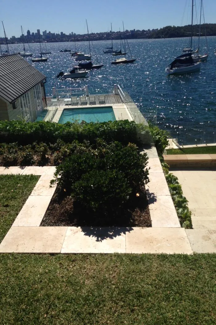 Harbourfront pool with travertine-edged garden beds